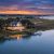 Charleston Coastal Homes with warm lights on a dock, reflections on calm water at sunset in a marshy inlet