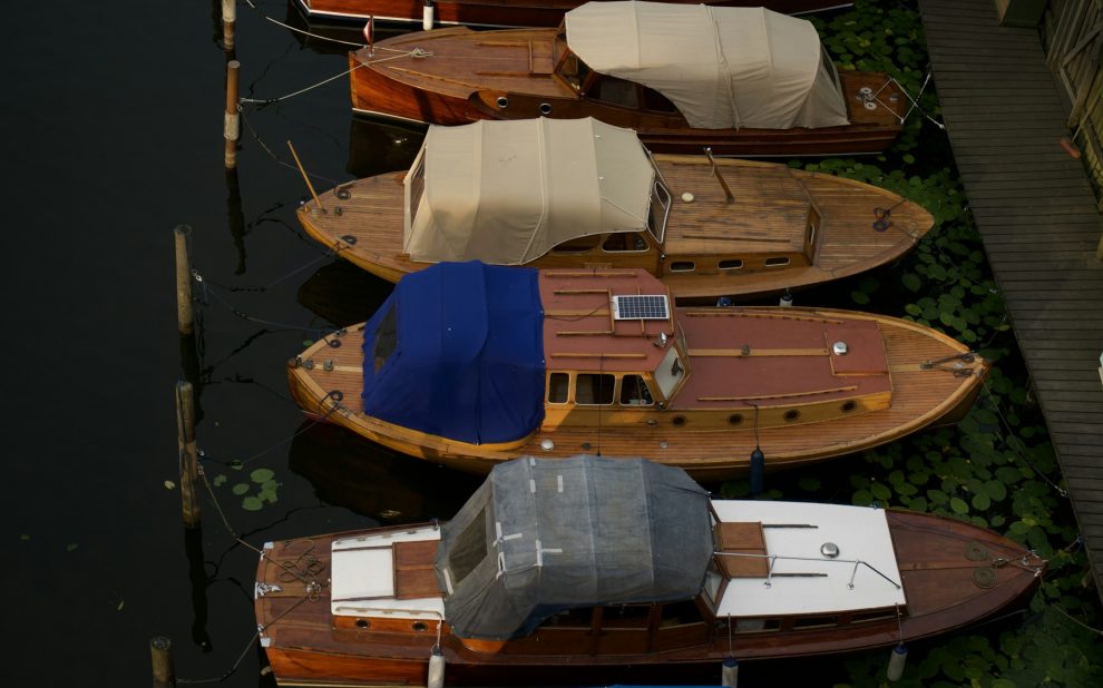 Boats protected with canvas covers beside a wooden dock